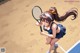 A girl holding a tennis racket on a tennis court.