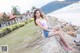 A woman sitting on a stone wall next to the ocean.