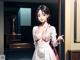A woman in a white dress pointing at something.